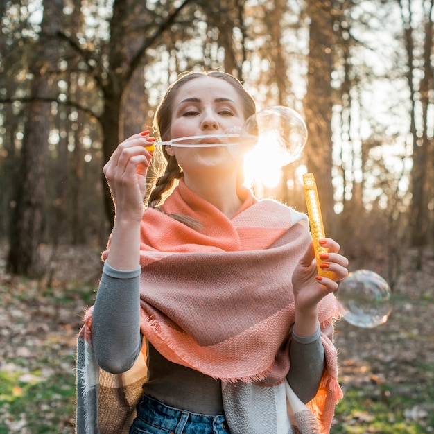 Free photo low angle woman making bubbles