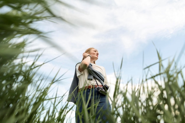 Free photo low angle of woman posing with grass