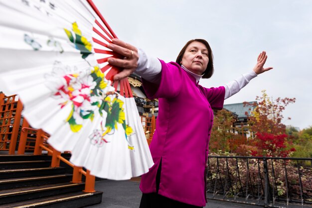 Low angle woman practicing tai chi outside