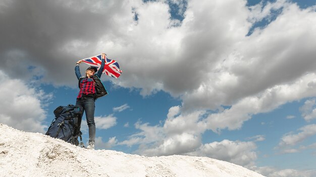 Low angle woman raising flag outdoors