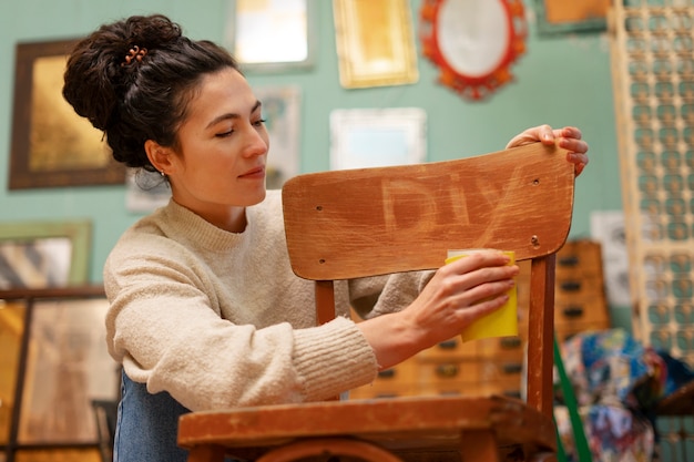 木製の椅子を復元するローアングルの女性