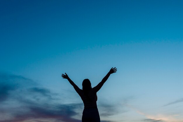 コピースペースと夕暮れ時の女性のシルエットの低角度