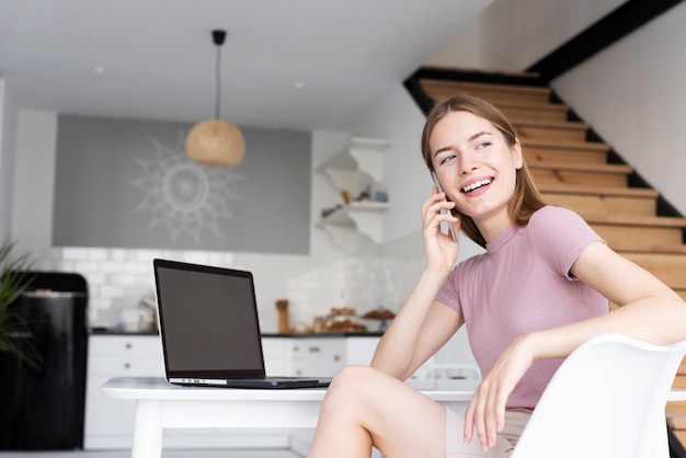 Free photo low angle woman sitting at her desk