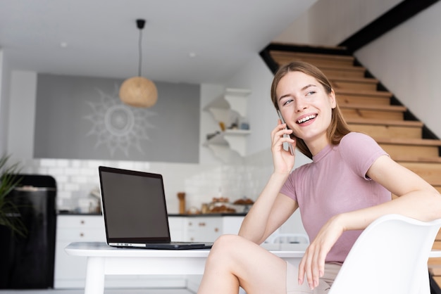 Low angle woman sitting at her desk