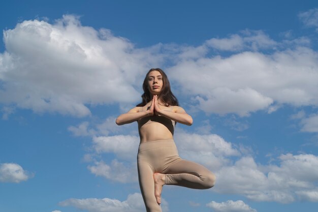 Low angle woman standing on one leg