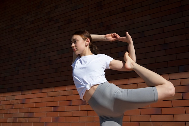 Free photo low angle woman stretching her leg