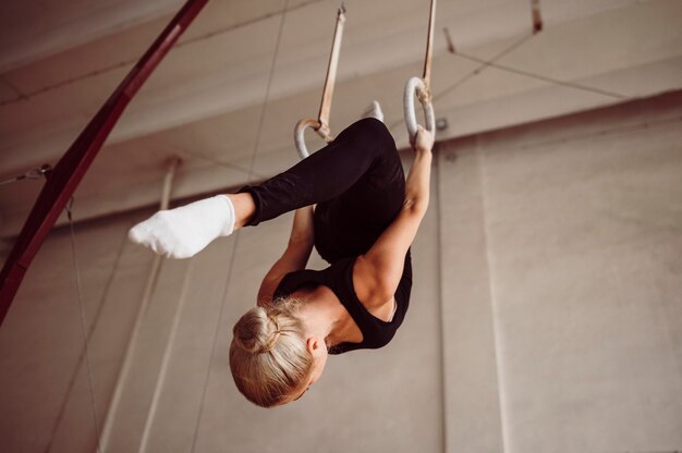 Тренировка женщины с низким углом на гимнастических кольцах
