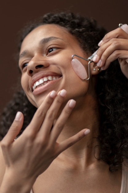 Free photo low angle woman using massage tool