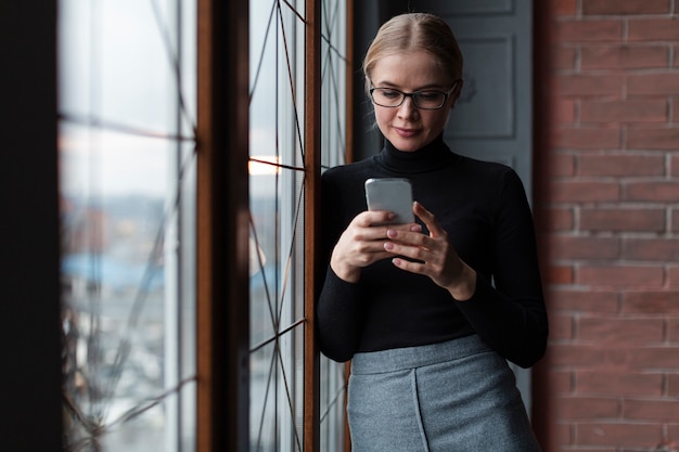 Foto gratuita donna di angolo basso che usando cellulare