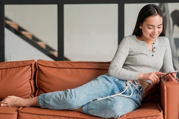 Foto gratuita donna di angolo basso che usando cellulare