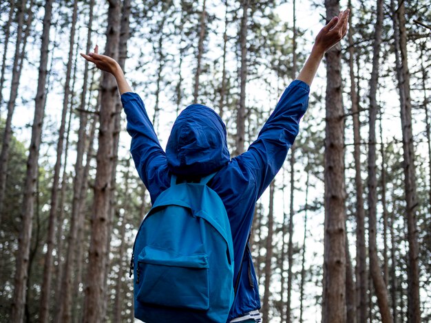 Low angle woman with backpack in forest