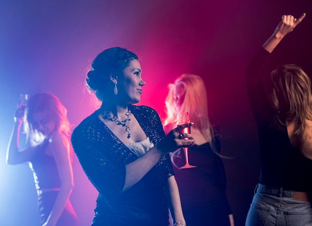 Low angle woman with drink dancing