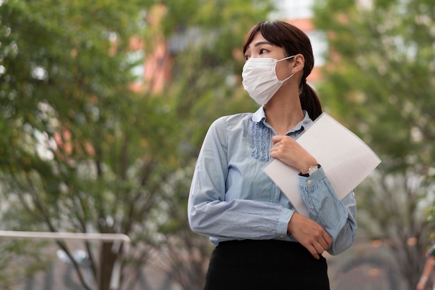 Free photo low angle of woman with face mask concept