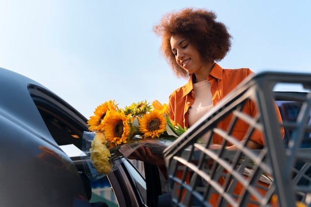 Free photo low angle woman with sunflowers