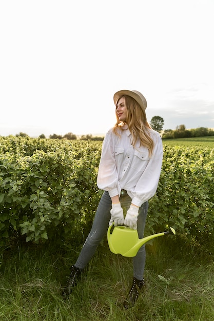 Low angle woman with watering can