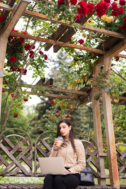 Low angle of woman working on laptop outdoors