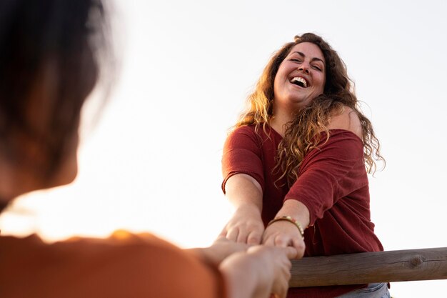 Low angle of women friends having fun outdoors