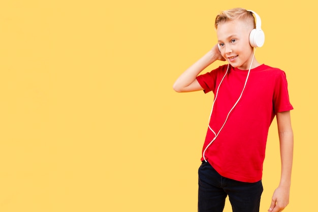 Low angle young boy listening music