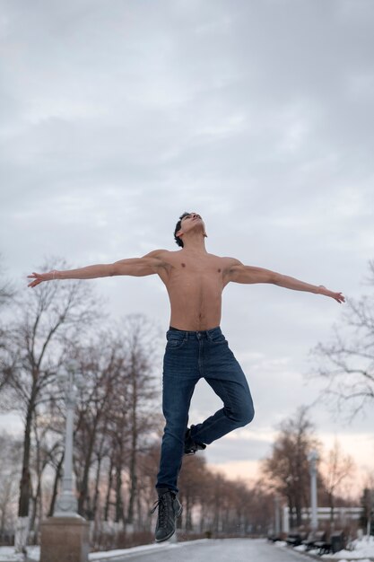 Giovane di angolo basso che esegue balletto all'aperto