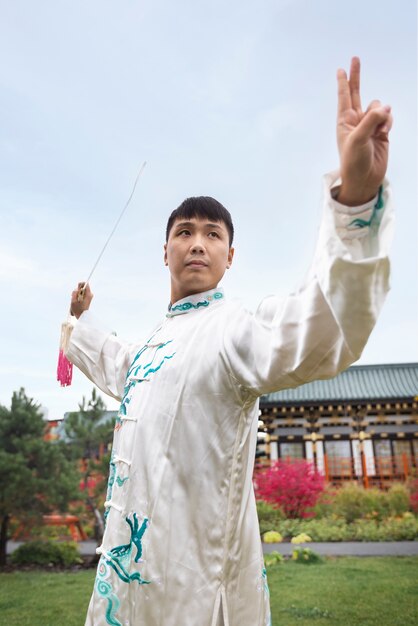 Low angle young man practicing tai chi