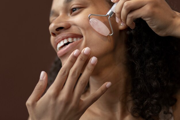 Low angle young woman using massage tool