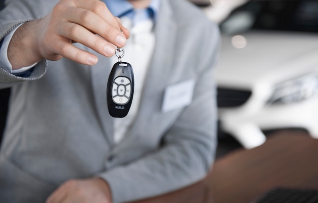 Low section of car salesman with car key