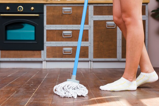 low section of a cleaner mopping floor in kitchen