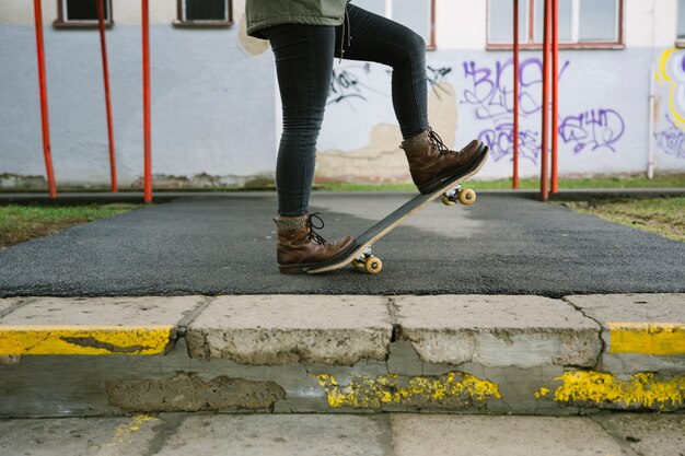 Low section of female standing on skateboard