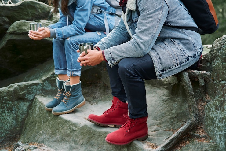 Free Photo low section of hikers with coffee sitting on rock