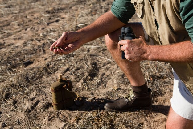 Low section of man holding mud on field