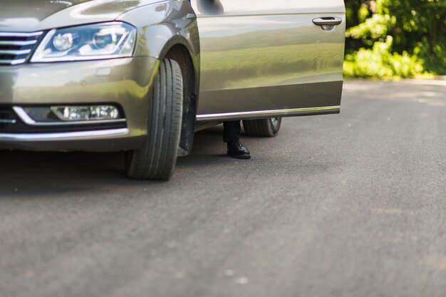 車のドアの後ろにある男の足の低い部分