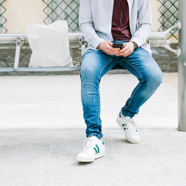 Low section of a man using smartphone