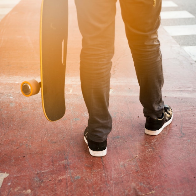 Low section of a person holding skateboard