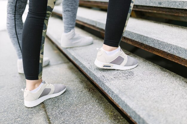 Low section of two female joggers on staircase