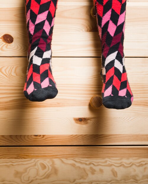 Low section view of a girl's feet with multi colored socks