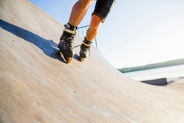 Free photo low section view of a man rollerskating in skate park