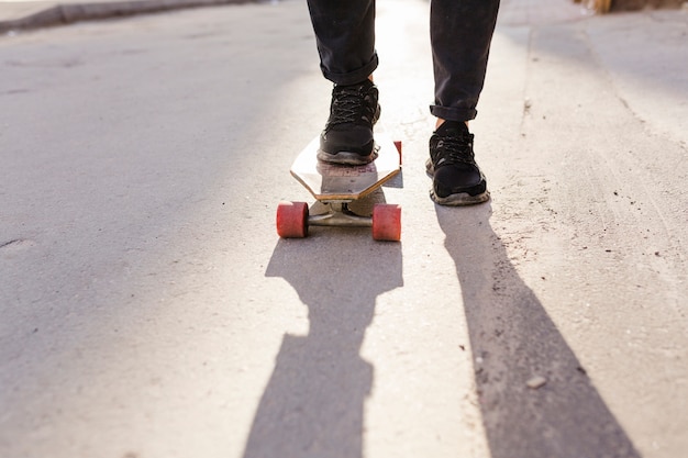 Low section view of a person's feet skating on street