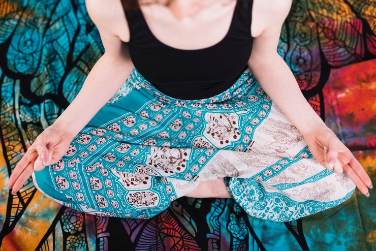 Free Photo low section of woman sitting in lotus pose with mudra gesture on blanket