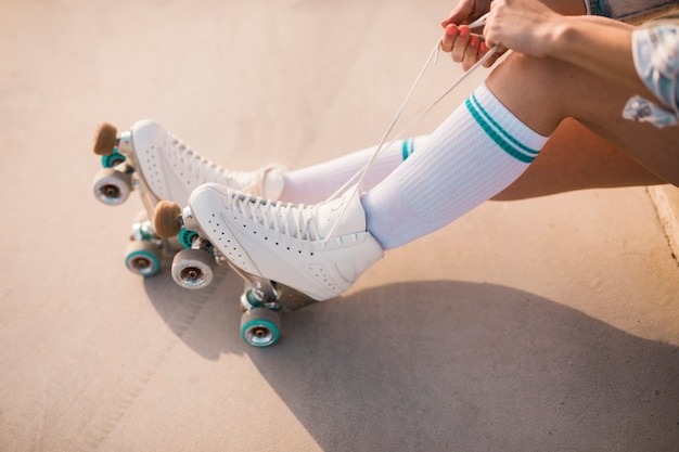 Low section of woman tying roller skate lace