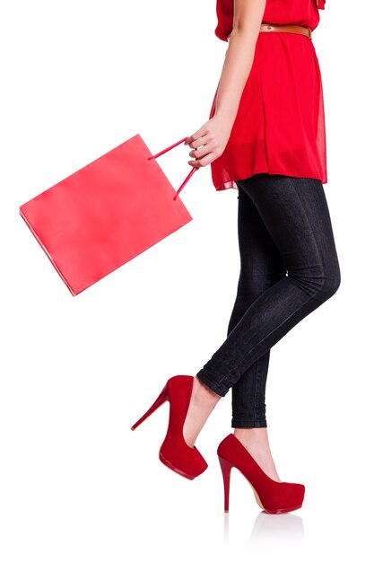 Low section of a woman with her red shopping bag