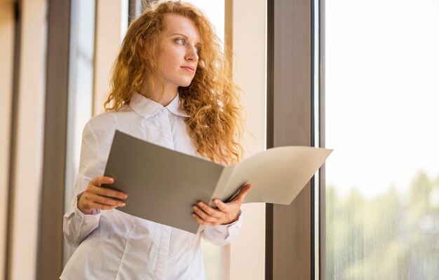 Low view businesswoman looking outside the window