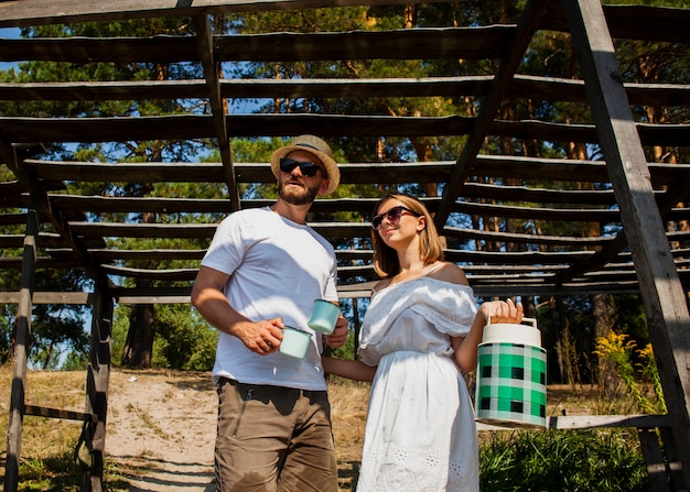 Free photo low view of couple looking away and holding a water tank