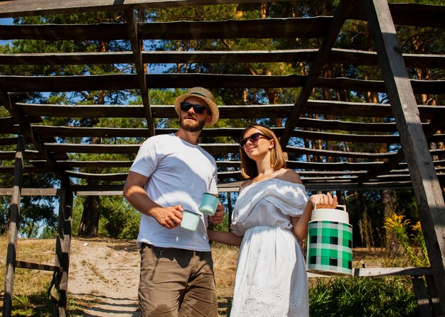 Low view of couple looking away and holding a water tank