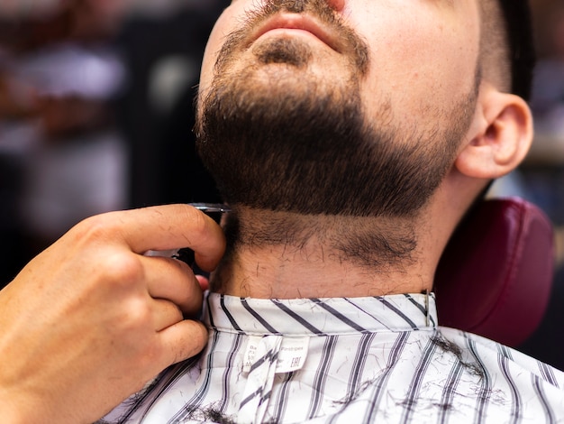 Free photo low view of customer getting his beard cut