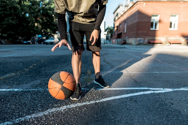 Foto gratuita vista bassa uomo con un pallone da basket