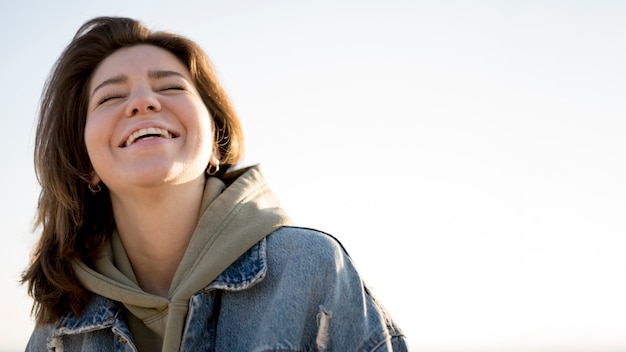 Foto gratuita ritratto di vista bassa della ragazza e del cielo di smiley