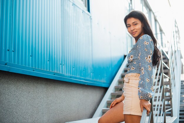 Low view sideways woman in white pants and floral shirt