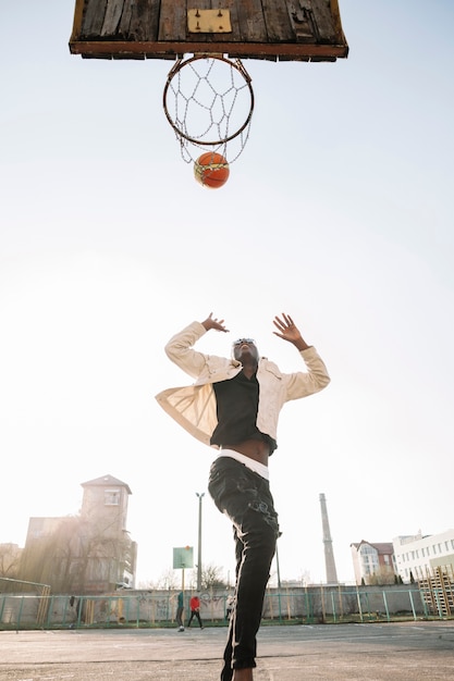 Low view teenager playing basketball outdoors