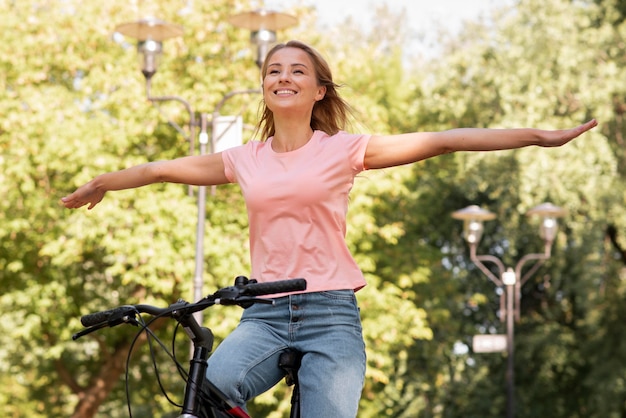 Low view woman riding without holding the bike with hands