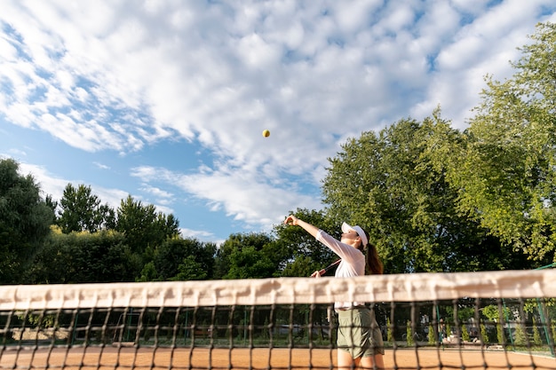 Low view woman serving during tennis match